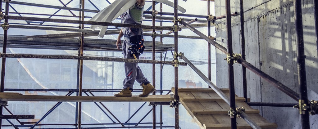 Τεχνίτης σε σκαλωσιά κατά τη διάρκεια ενεργού εργοταξίου.