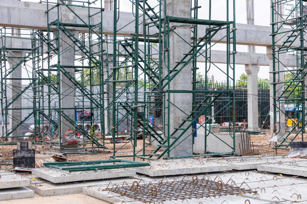 Πράσινη σκαλωσιά σε οπλισμένο σκυρόδεμο με κολώνες και δοκάρια.